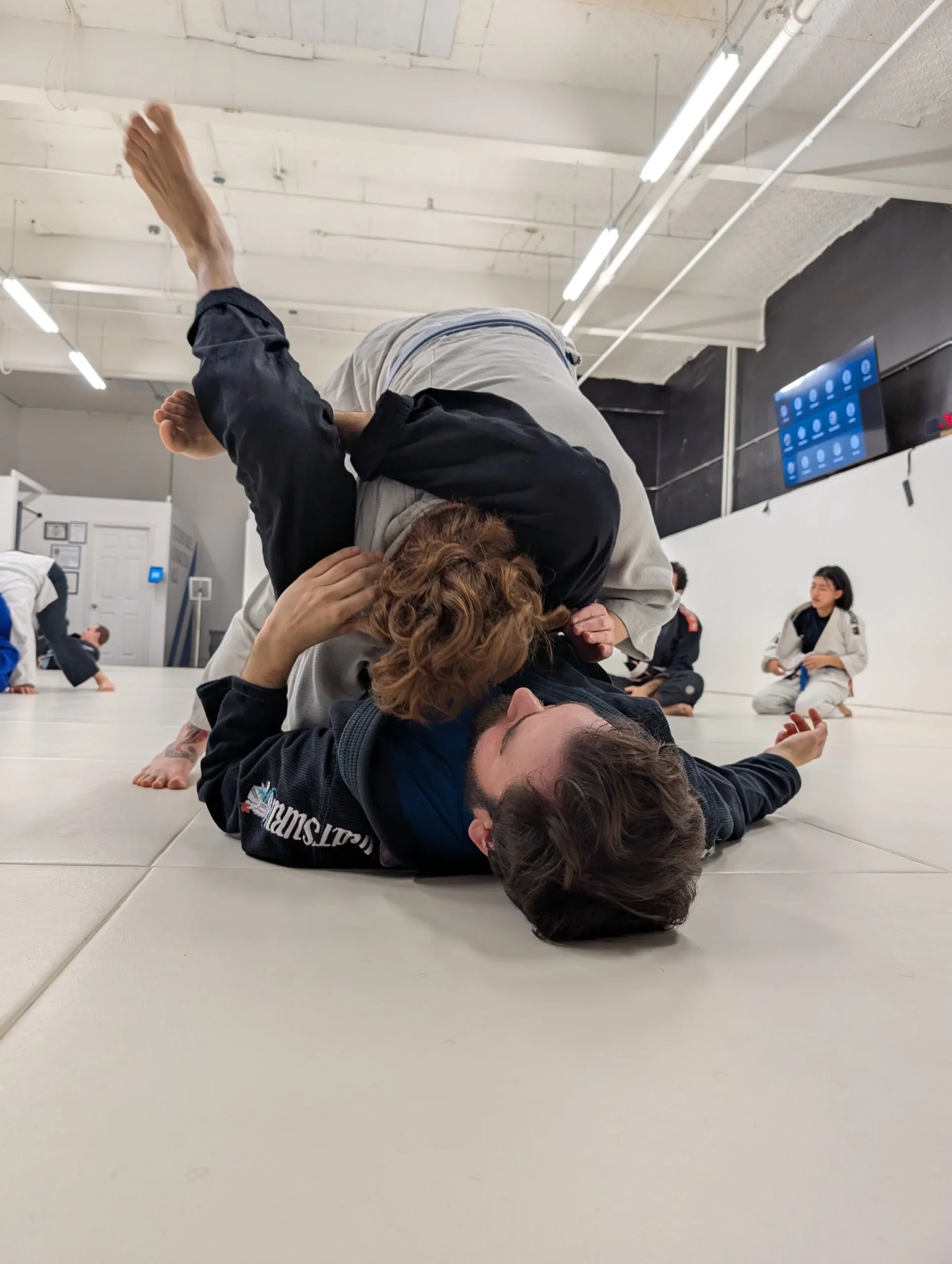 Brazilian jiu-jitsu rolling at Plateau BJJ during technique practice.